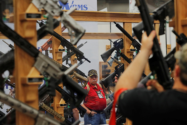 Gun enthusiasts looking at rifles during the annual National Rifle Association convention in Dallas, Texas.