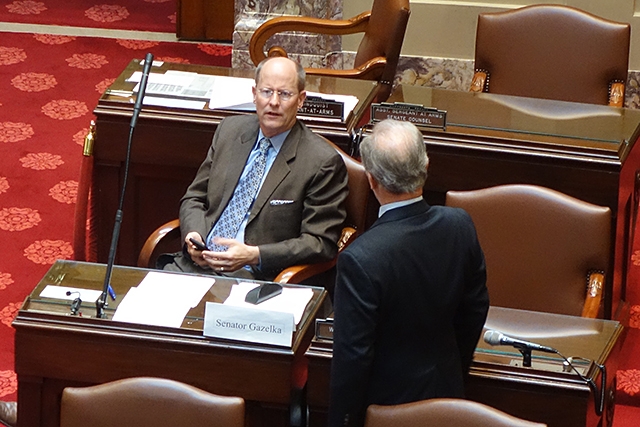 Senate Majority Leader Paul Gazelka speaking with Sen. Warren Limmer in close proximity on the Senate Floor.