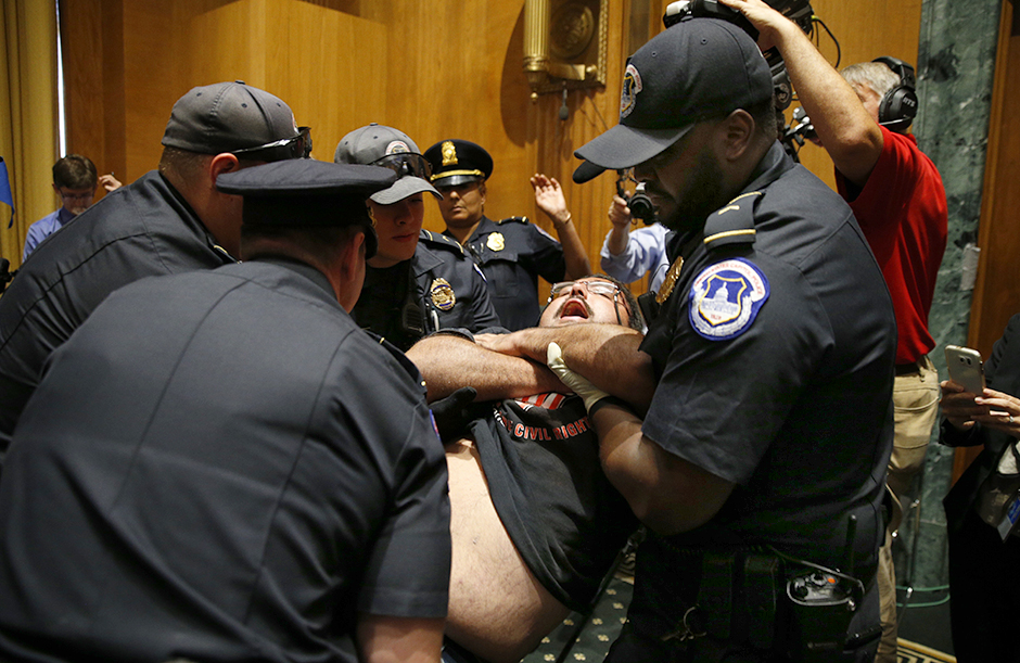 A disabled protester is pulled from his wheelchair and removed by Capitol Hill police officers during a Senate Finance Committee hearing on a Republican effort to repeal and replace the Affordable Care Act on September 25, 2017.