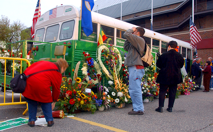 People attending the service for Senator Paul Wellstone leaving flowers at the school bus before the start of the memorial service at Williams Arena on October 29, 2002.